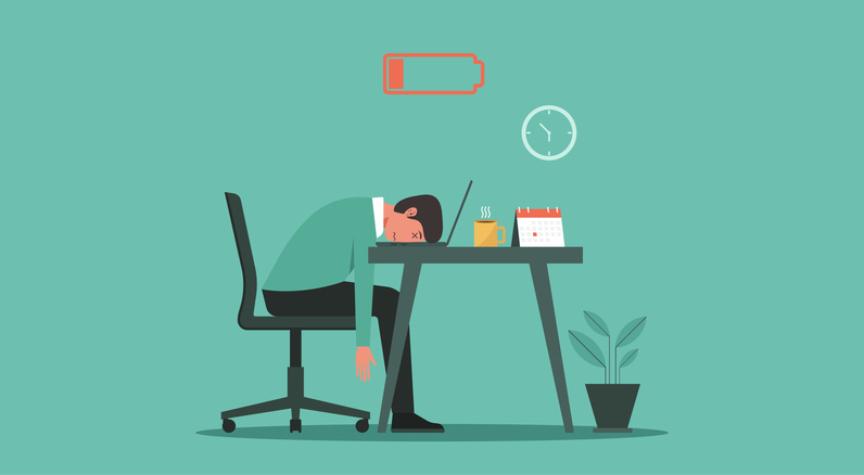 Illustration of an exhausted IT worker slumped at a desk with a low battery icon overhead